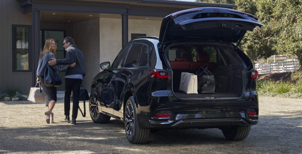 Happy couple unloading shopping bags from a new Mazda CX-70